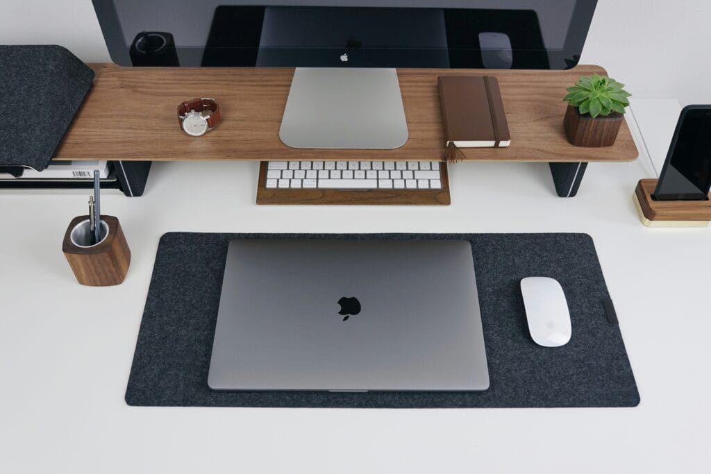 Flat lay of a modern tech workspace with laptop, wireless mouse, keyboard, notebook, and plant, representing TopSmartTrends' curated product mission