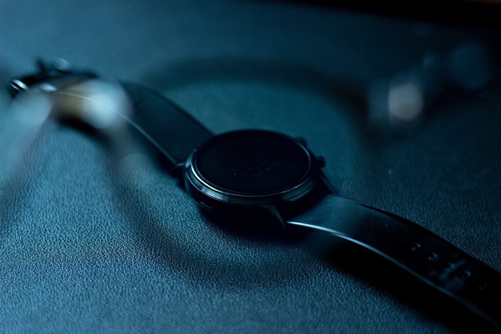 Fitbit Luxe alongside a traditional analog wrist watch